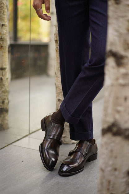 Hand-Polished Smoked Chocolate Double Monk Strap Shoes – worn by a man in cuffed dark blue jeans, showcasing unique character and modern elegance.
