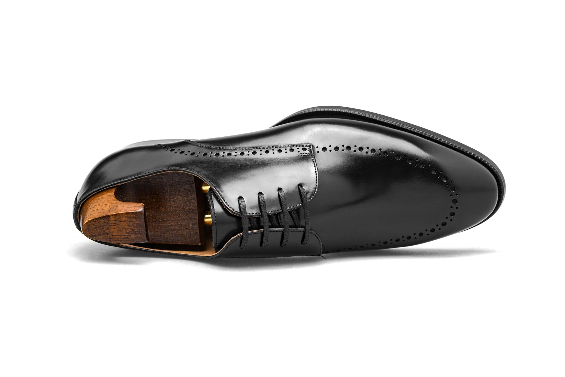 Polished Black Half-Brogue Derby shoe – high-shine leather finish, side view with shoe tree and elegant broguing. 
