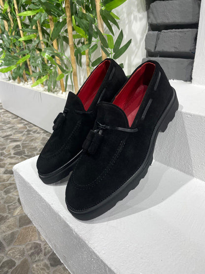Handcrafted Black Suede Tassel Loafers with Chunky Soles – pair on a white ledge, highlighting premium black suede, red lining, and classic tassel details.