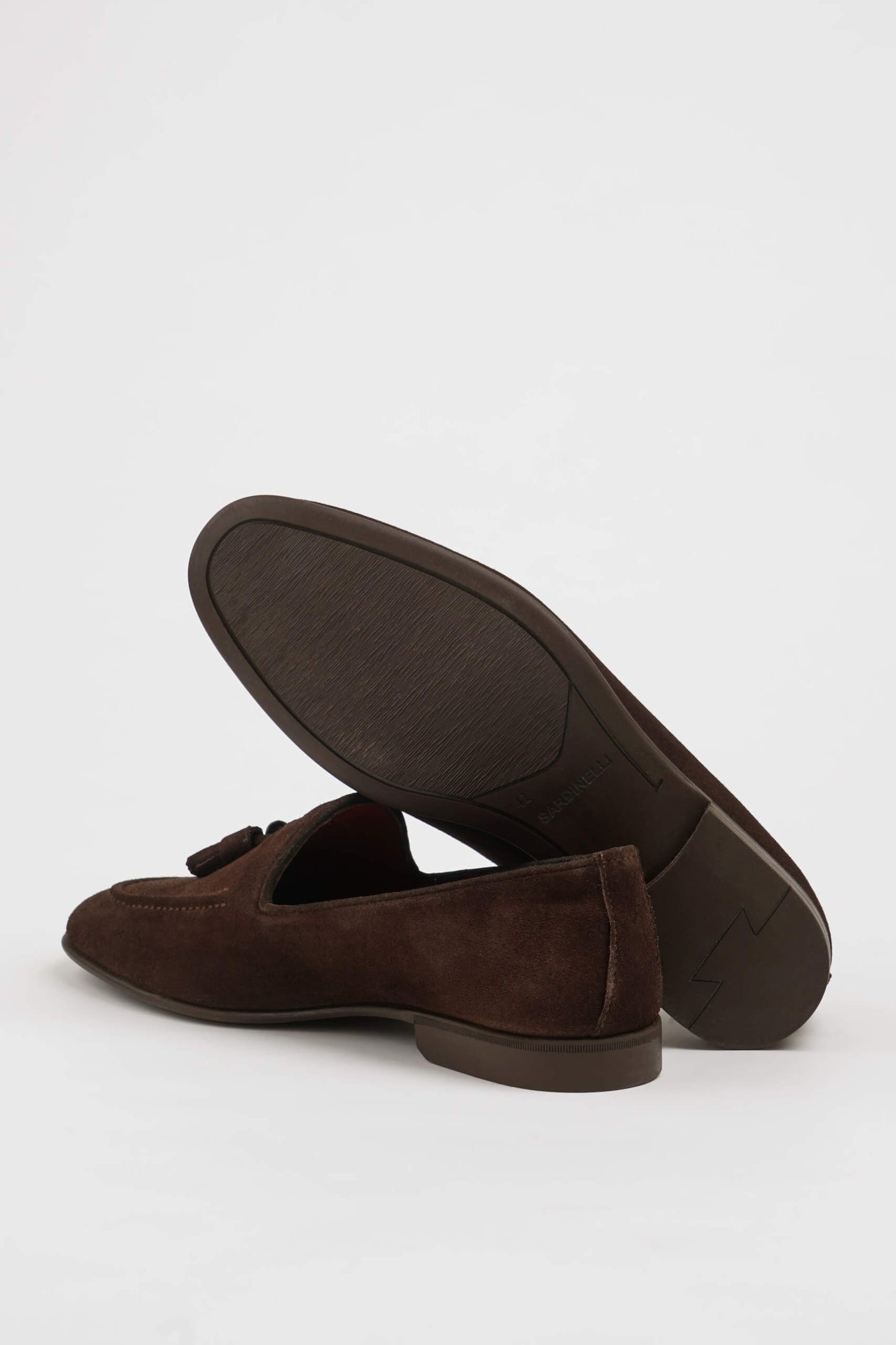 Handcrafted Brown Suede Tassel Loafers for Men – pair on white background with one shoe upright, showing the sole and classic tassel design.