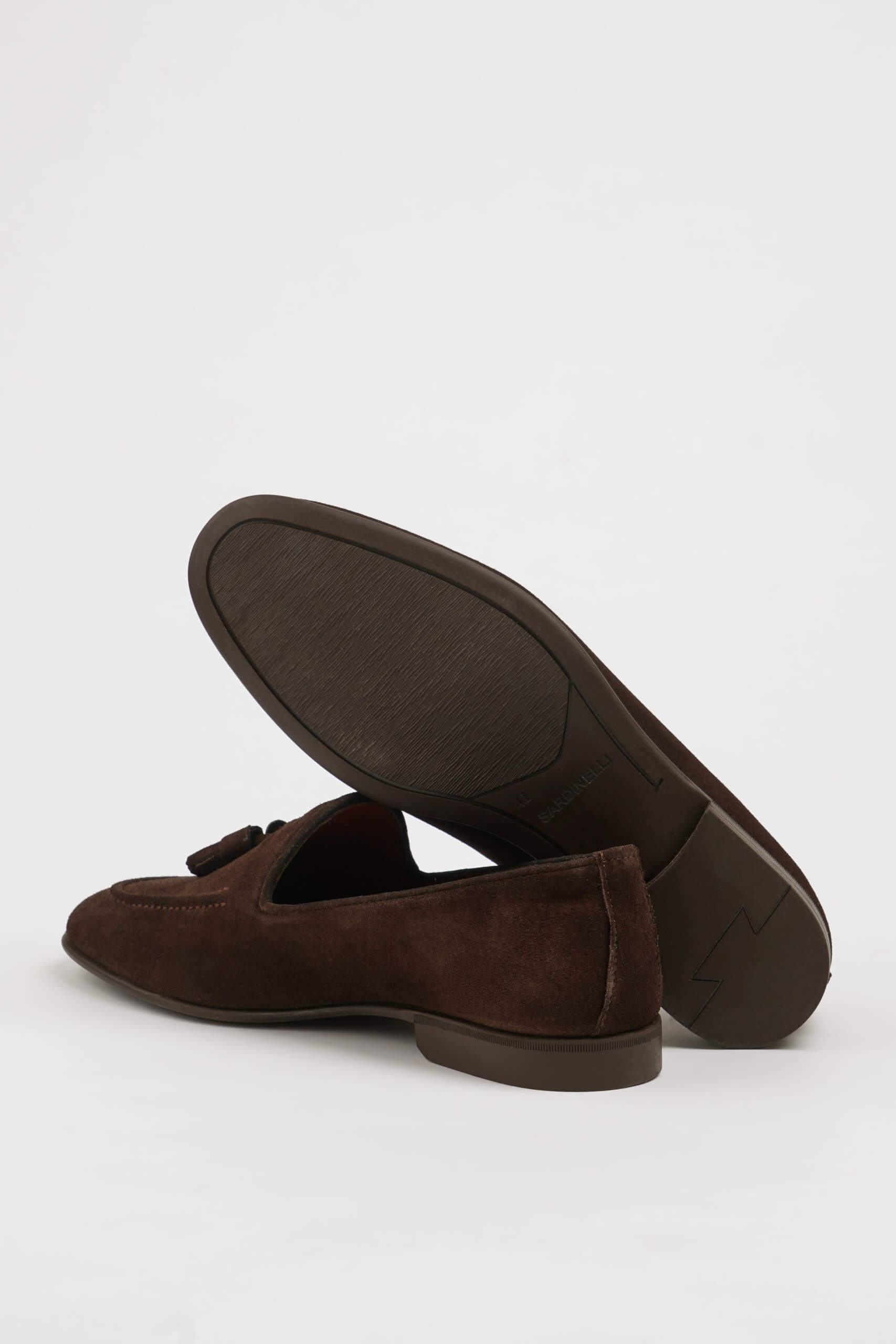 Handcrafted Brown Suede Tassel Loafers for Men – pair on white background with one shoe upright, showing the sole and classic tassel design.