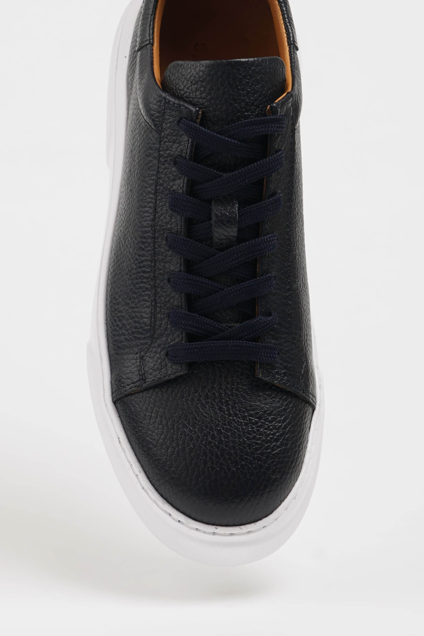 Handcrafted Black Grained Leather Sneakers with Pool Sole – one shoe showing the textured white sole with reliable traction, the other upright.