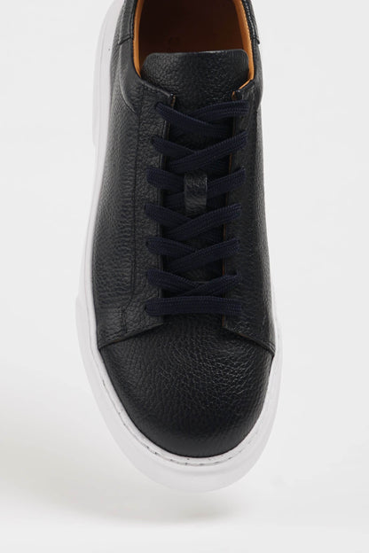 Handcrafted Black Grained Leather Sneakers with Pool Sole – one shoe showing the textured white sole with reliable traction, the other upright.