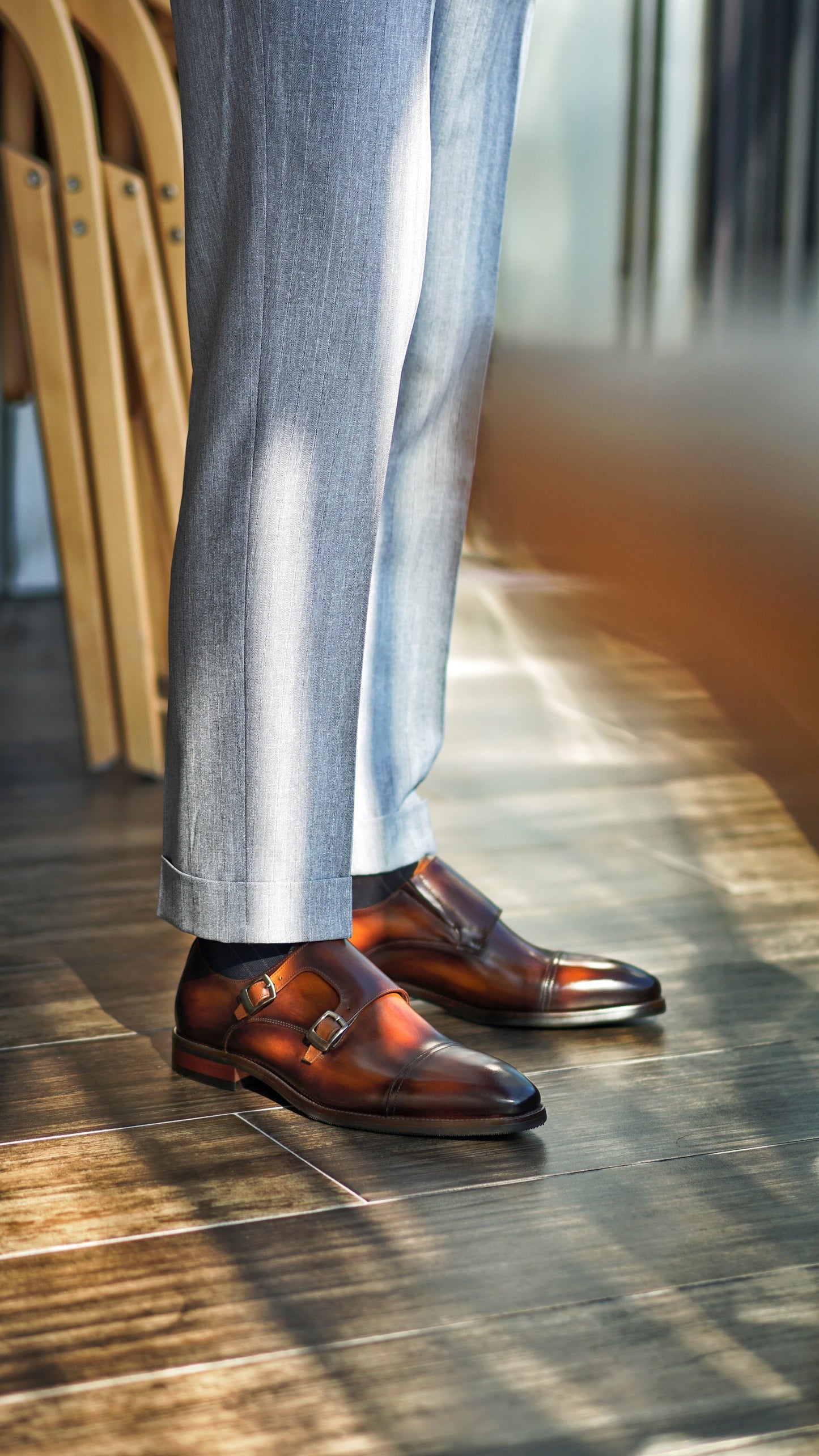 Handmade Brown Double Monk Strap Dress Shoes – rich brown patina leather, worn by a man in light grey trousers, showcasing formal-to-casual versatility.