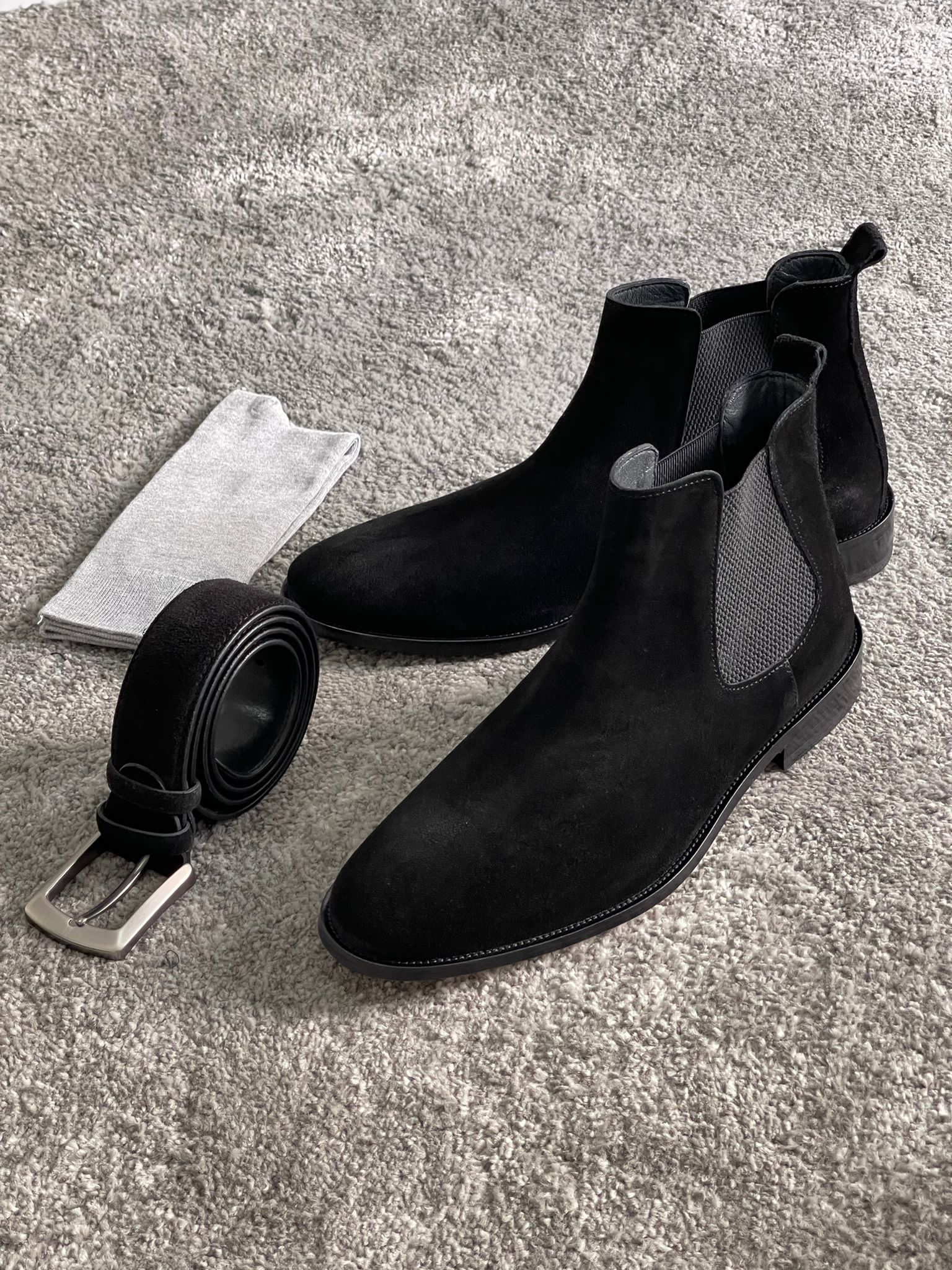 Handmade Classic Black Suede Chelsea Boots – a side view of a pair of black suede boots next to a belt and socks.