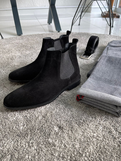 Handmade Classic Black Suede Chelsea Boots – a side view of the boots next to rolled-up gray pants, a belt, and socks.