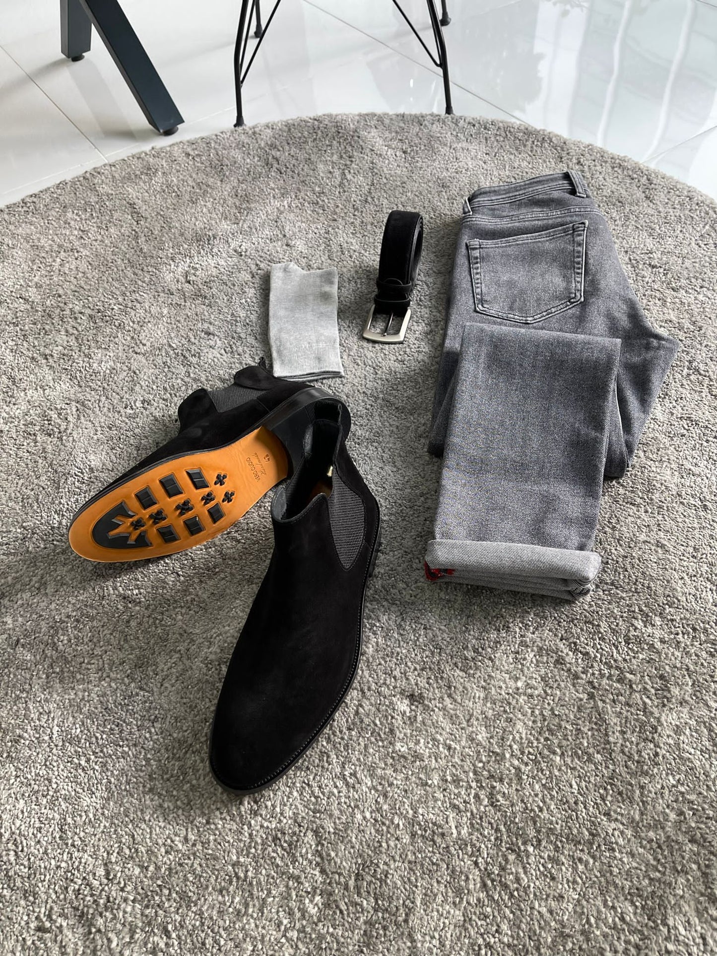 Handmade Classic Black Suede Chelsea Boots – a flat-lay of the boots with a belt, socks, and gray pants, showing a complete outfit.