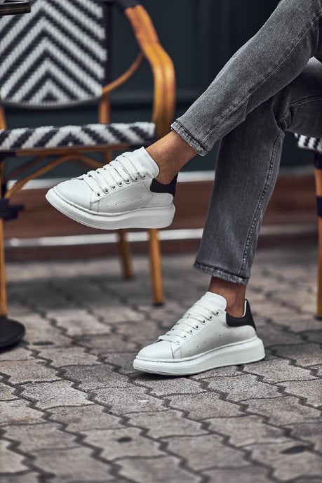 Handmade White Leather Sneakers - Luxury Comfort for Every Occasion – worn by a man, showcasing the contrasting black heel tab and bold silhouette, perfect for everyday style.
