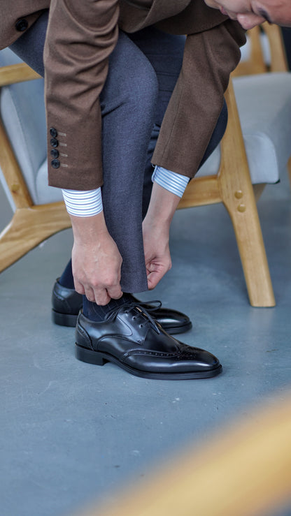 Black leather wingtip dress shoes for men.