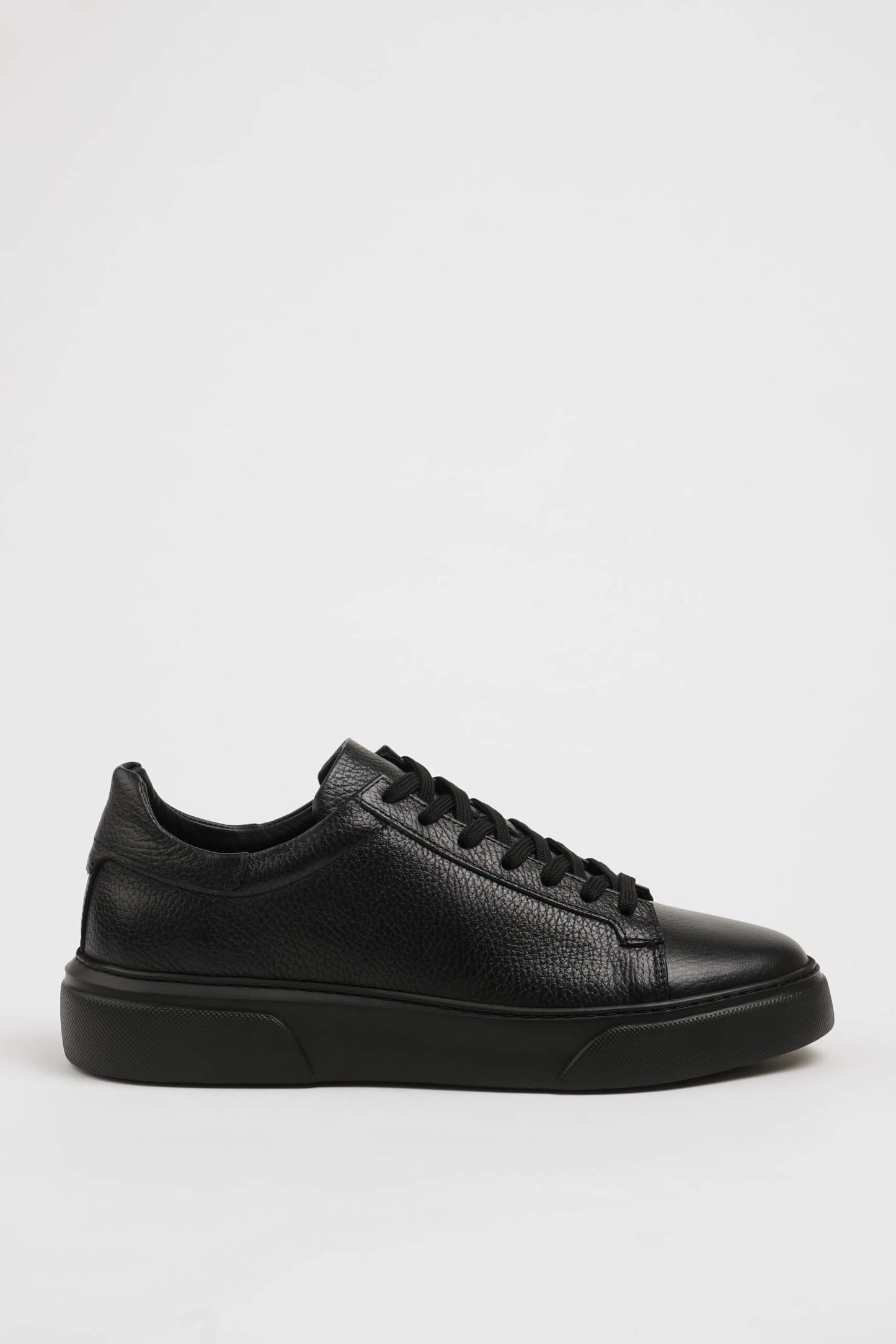 All Black Grained Leather Sneaker for Minimalist Style – side view on white background, showcasing rich black leather and all-black sole.
