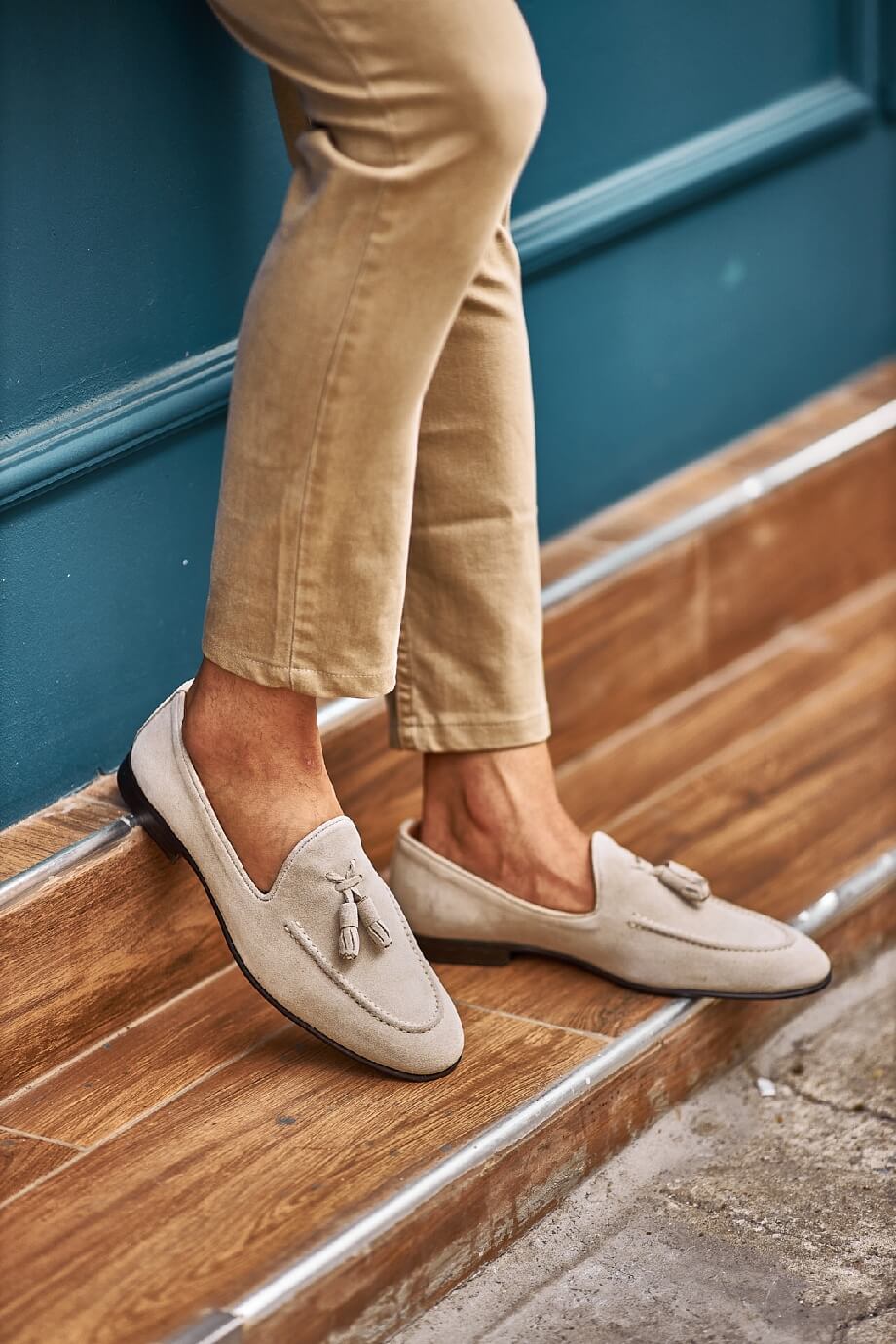 HolloShoe Beige Suede Tassel Loafers - Sophisticated Leather Footwear – worn by a man in tan chinos, standing on wooden steps, showcasing timeless style.