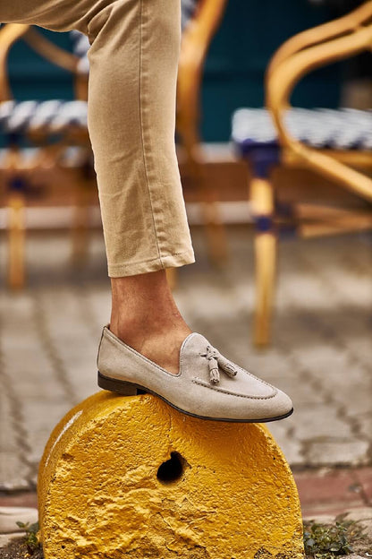 HolloShoe Beige Suede Tassel Loafer - Sophisticated Leather Footwear – worn by a man in tan chinos, standing on a yellow concrete block, highlighting the high-quality suede leather and timeless style.