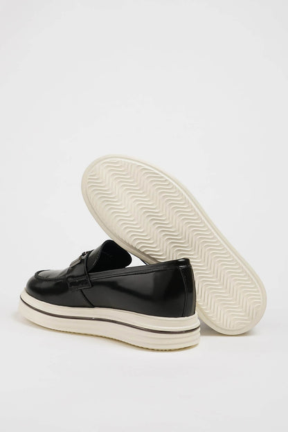 HolloShoe Black Leather Slip-On Loafers with Horsebit Detailing – pair on a white background with one shoe showing the textured white sole for grip and comfort.