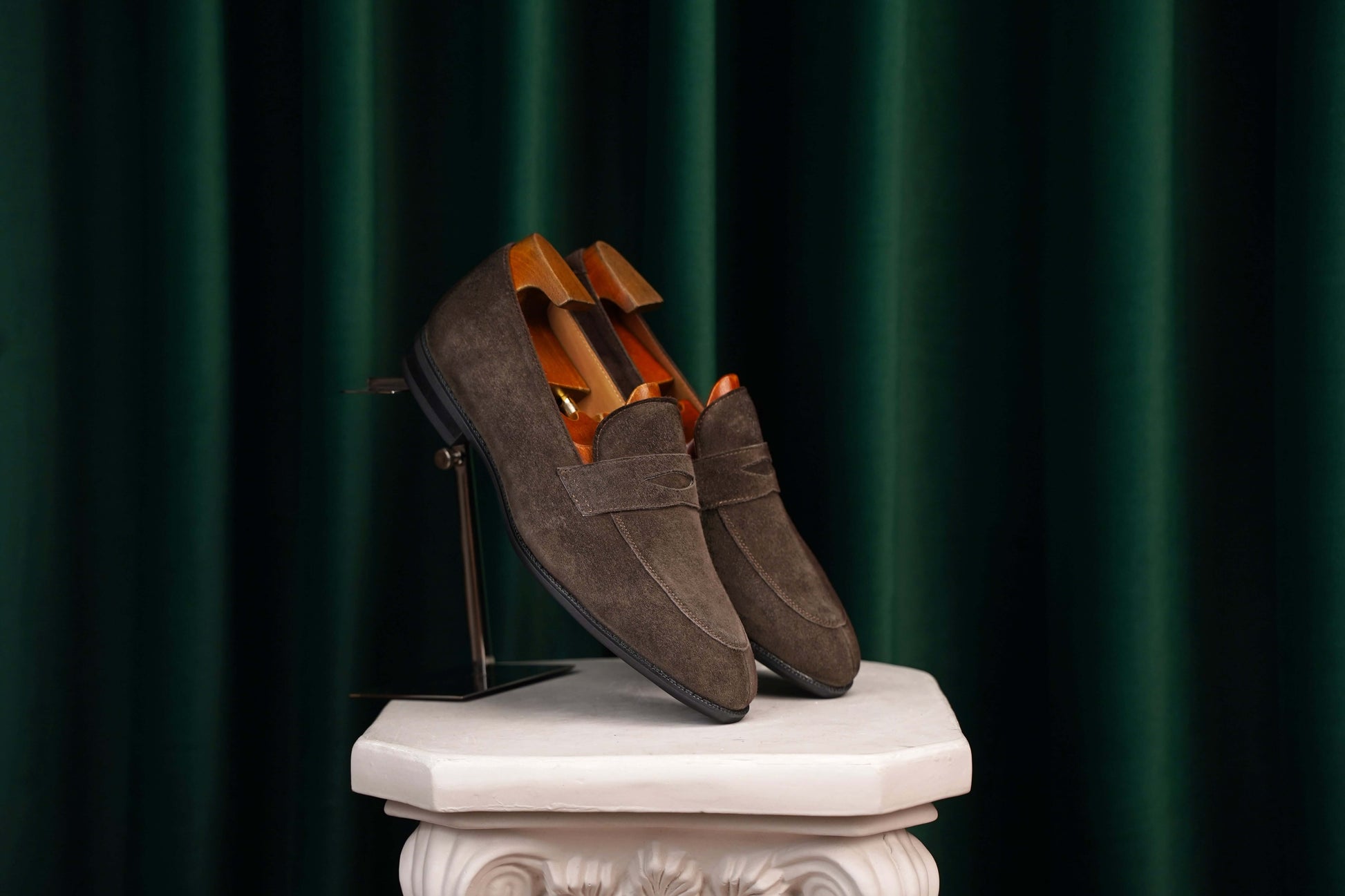 HolloShoe Earth Brown Suede Penny Loafers – pair with shoe trees, displayed on a stand, showcasing refined minimalism and soft brown suede.