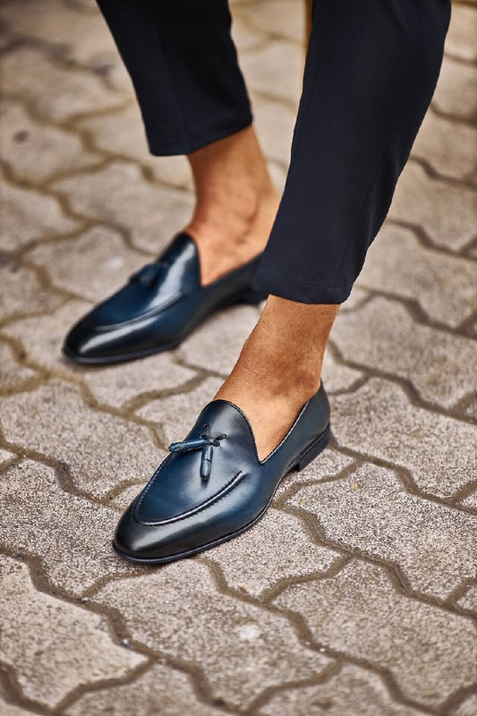 HolloShoe Navy Blue Tassel Loafers - Sophisticated Leather Footwear – worn by a man in black trousers, standing on a paved ground, showcasing an elegant navy blue hue and refined design.