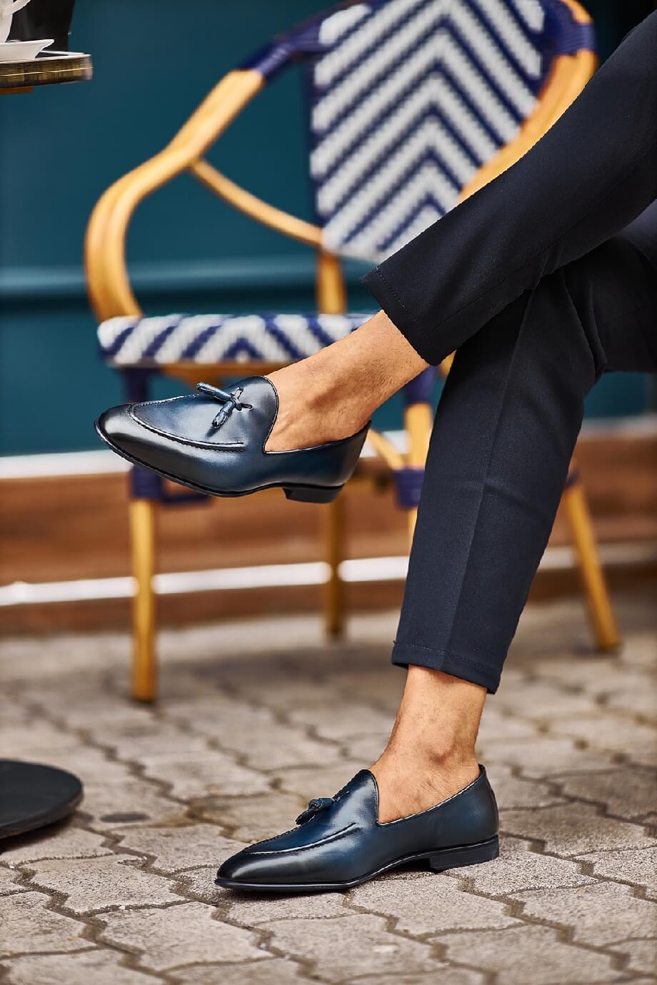 HolloShoe Navy Blue Tassel Loafers - Sophisticated Leather Footwear – worn by a man in black trousers, sitting on an outdoor chair, highlighting comfort and versatile style.