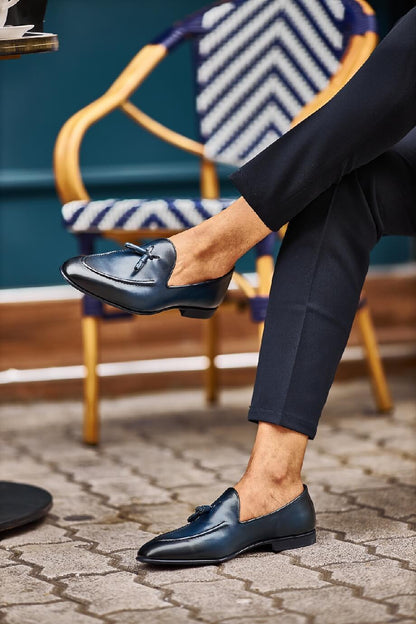 HolloShoe Navy Blue Tassel Loafers - Sophisticated Leather Footwear – worn by a man in black trousers, sitting on an outdoor chair, highlighting comfort and versatile style.