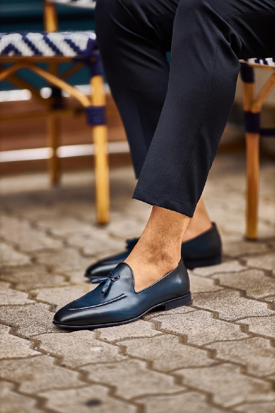 HolloShoe Navy Blue Tassel Loafers - Sophisticated Leather Footwear – worn by a man in cuffed black trousers, sitting outdoors, showcasing a sophisticated and sharp look.