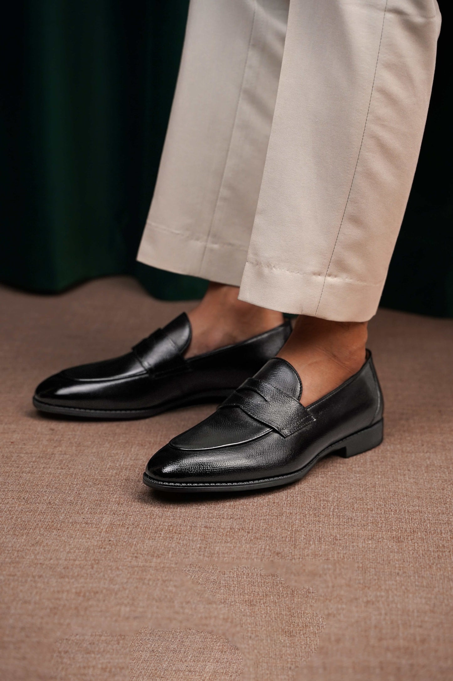 HolloShoe Black Penny Loafers – pair on a white pedestal, showcasing polished black textured leather and classic design with shoe trees.