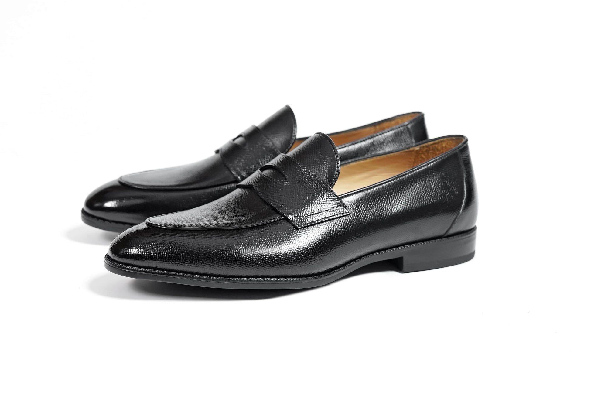 HolloShoe Black Penny Loafers – pair on a white background, highlighting the sleek silhouette and textured black leather.