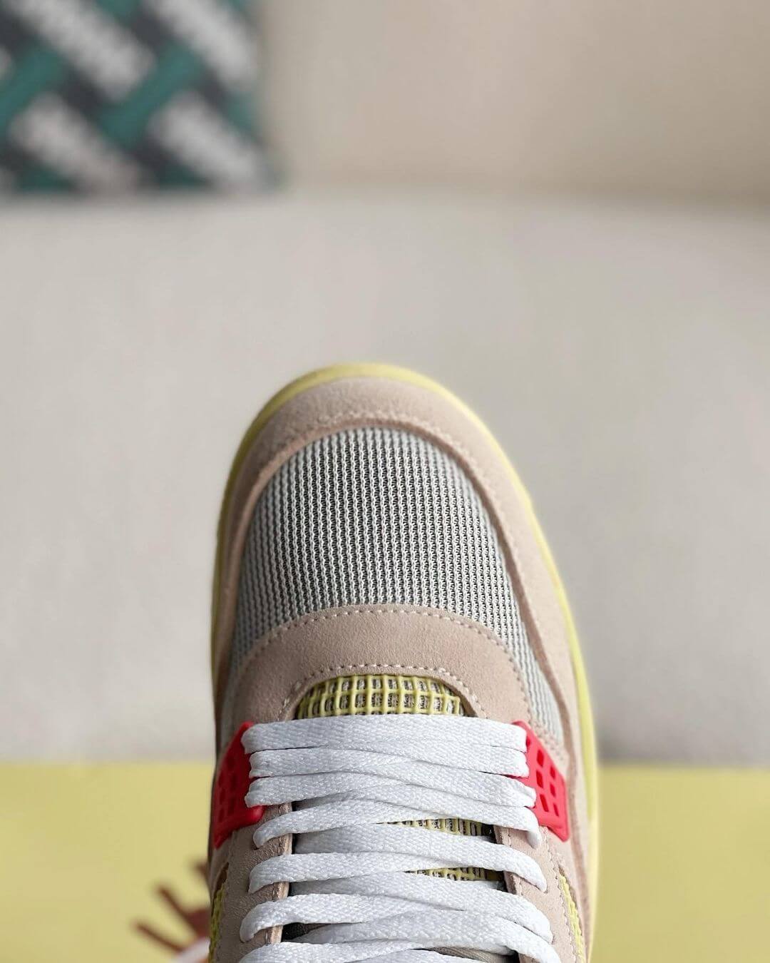 Union LA x Air Jordan 4 'Guava Ice' sneakers with a beige suede upper, vibrant pink, blue, and yellow accents, and vintage-inspired yellow midsole