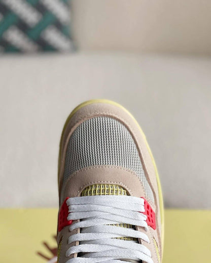 Union LA x Air Jordan 4 'Guava Ice' sneakers with a beige suede upper, vibrant pink, blue, and yellow accents, and vintage-inspired yellow midsole