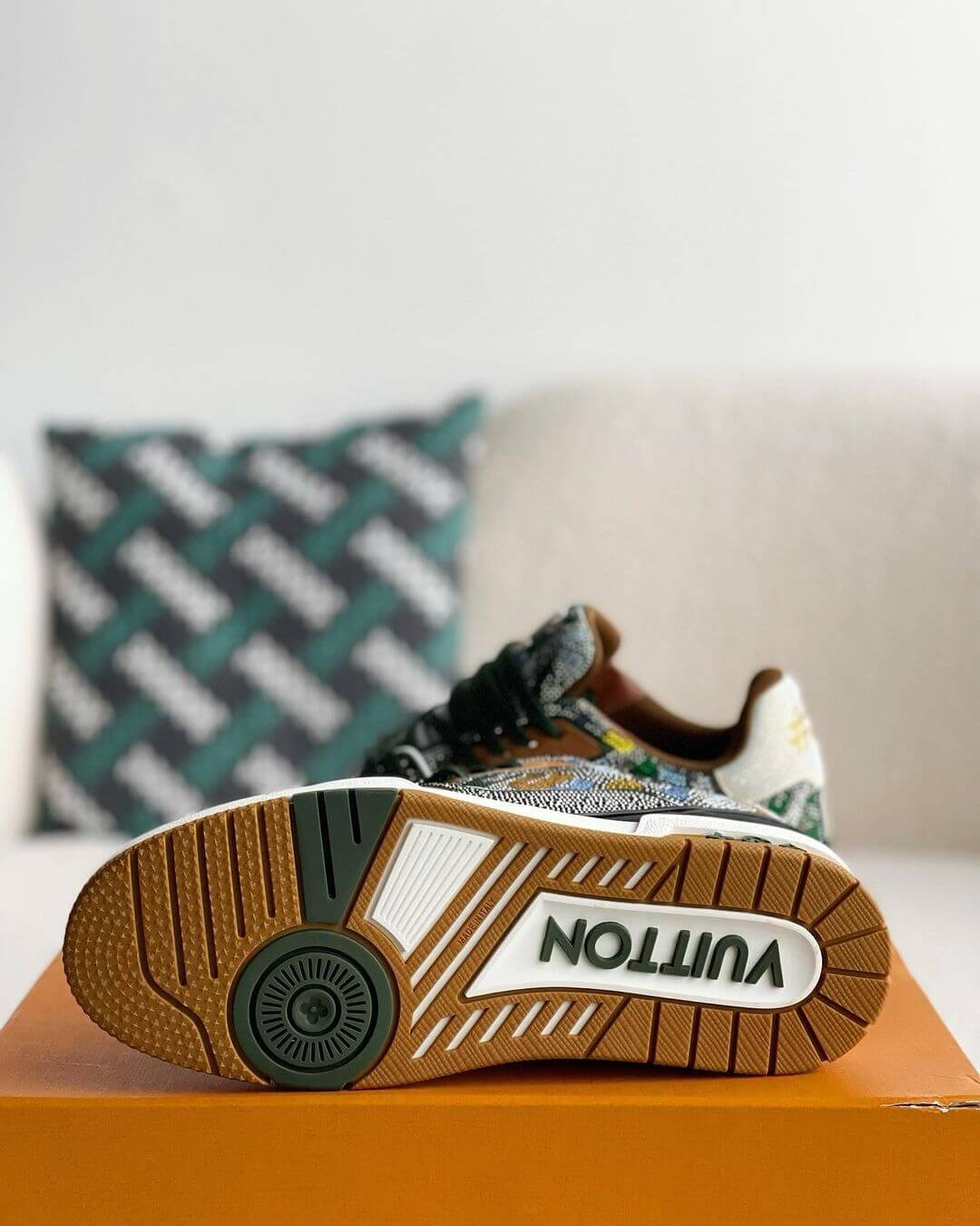 Louis Vuitton LV Trainer Sneaker with intricate beaded detailing, featuring a mix of earthy tones including green, brown, and white, with premium leather accents and a gum outsole, 