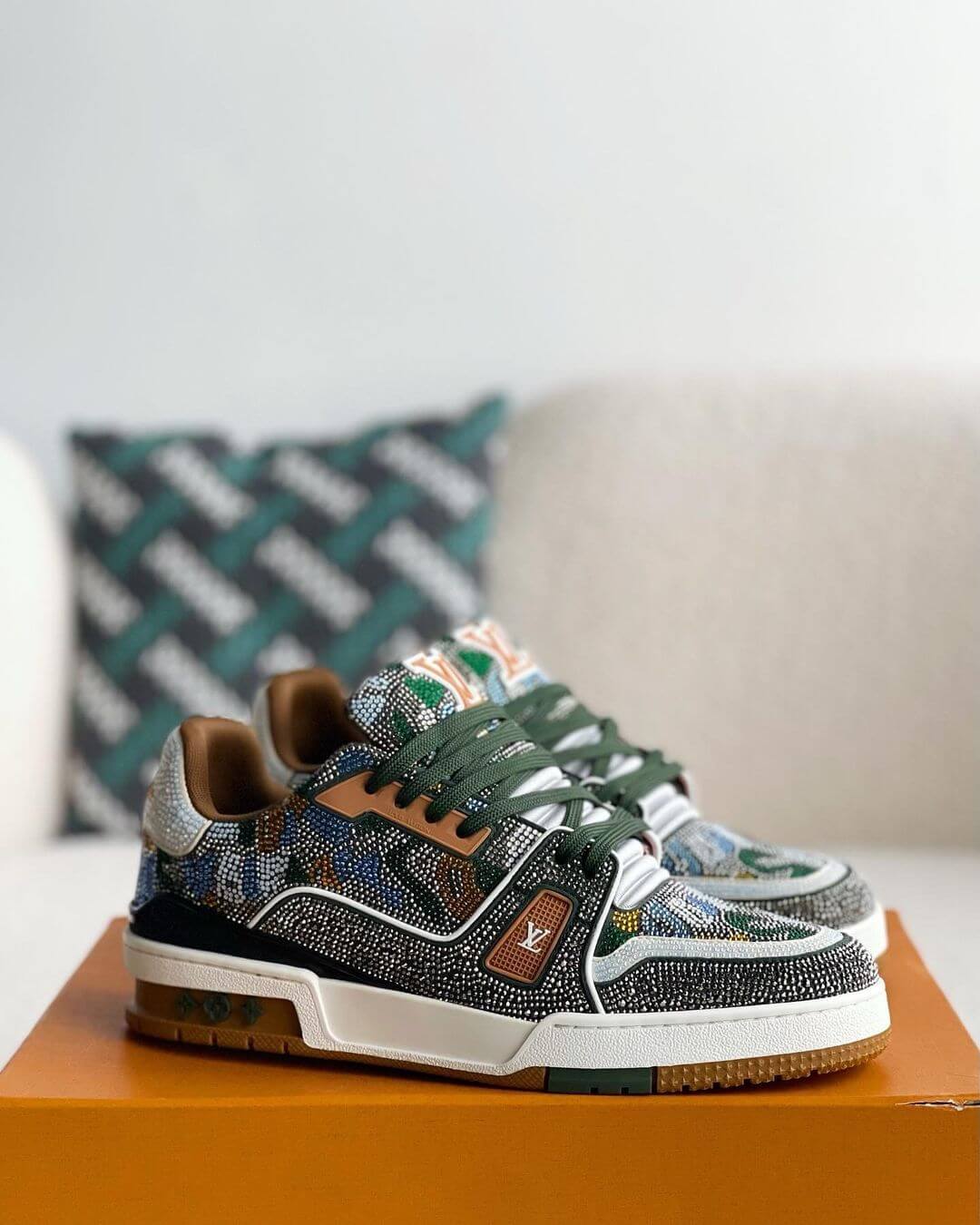 Louis Vuitton LV Trainer Sneaker with intricate beaded detailing, featuring a mix of earthy tones including green, brown, and white, with premium leather accents and a gum outsole, 