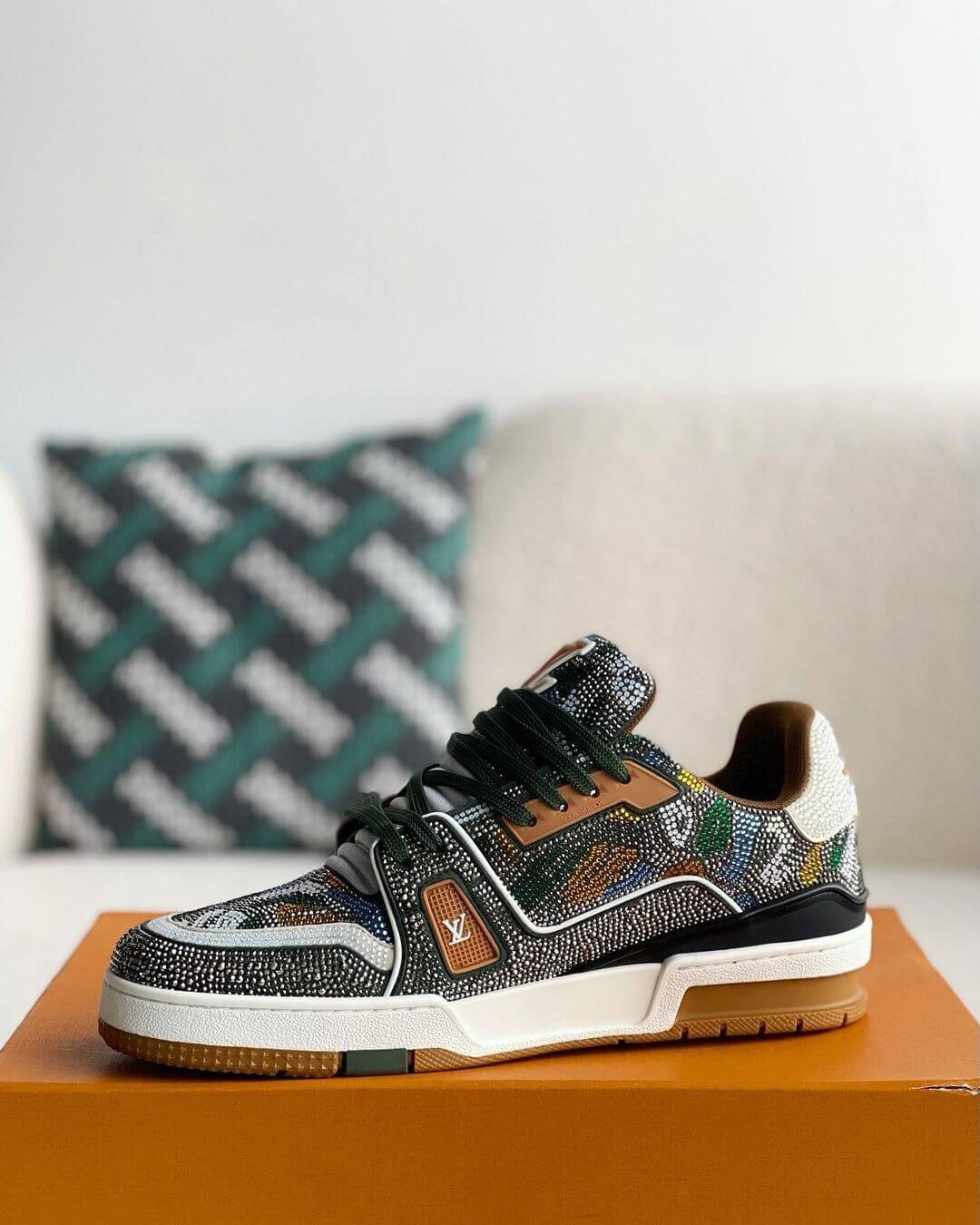 Louis Vuitton LV Trainer Sneaker with intricate beaded detailing, featuring a mix of earthy tones including green, brown, and white, with premium leather accents and a gum outsole, 