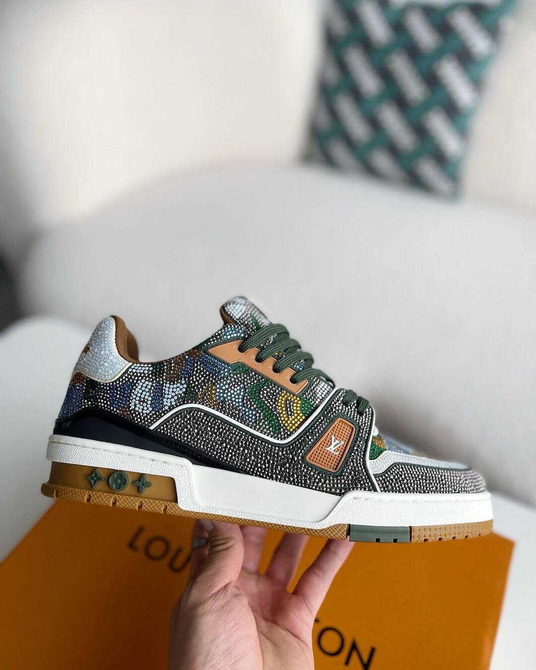 Louis Vuitton LV Trainer Sneaker with intricate beaded detailing, featuring a mix of earthy tones including green, brown, and white, with premium leather accents and a gum outsole, 