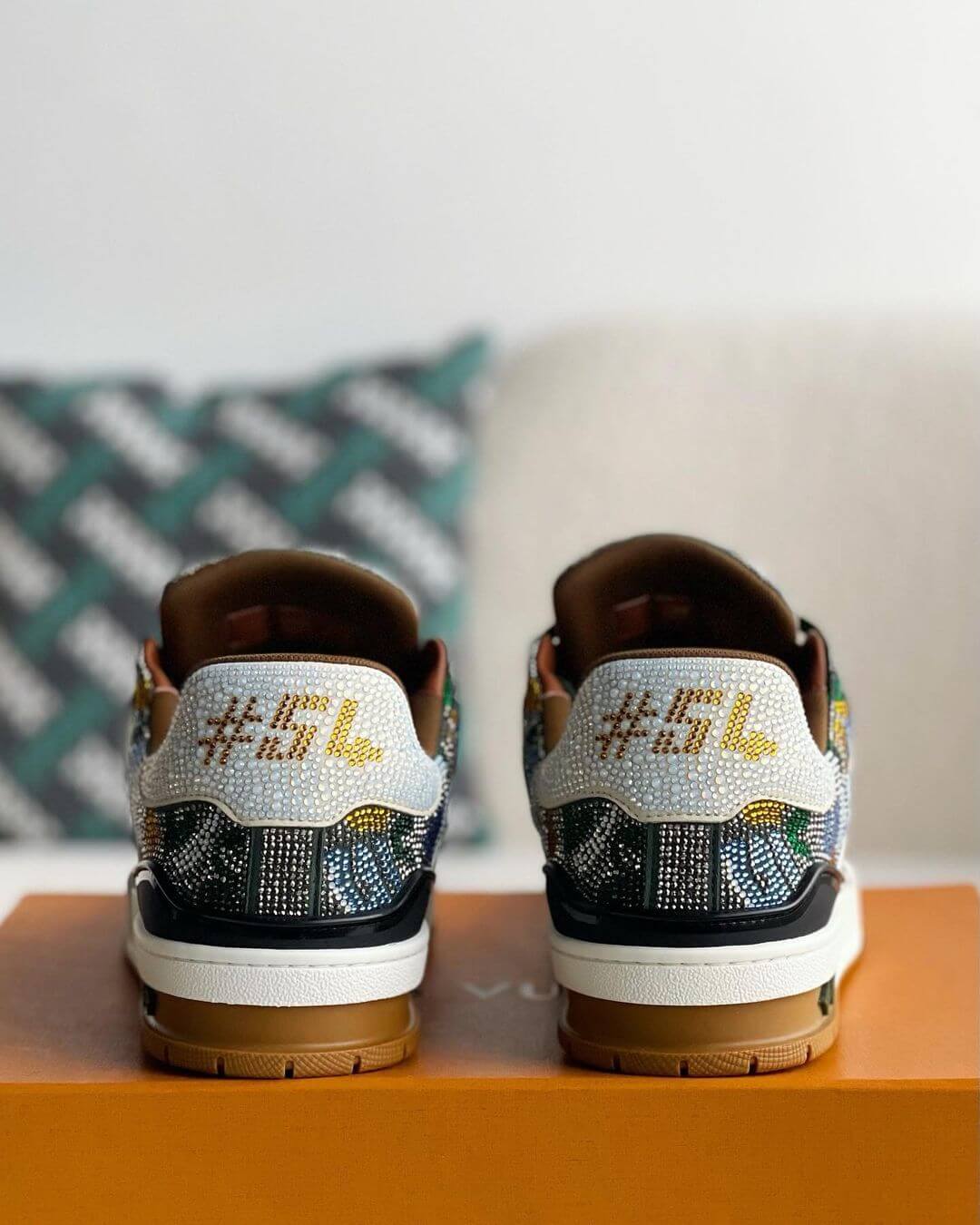 Louis Vuitton LV Trainer Sneaker with intricate beaded detailing, featuring a mix of earthy tones including green, brown, and white, with premium leather accents and a gum outsole, 