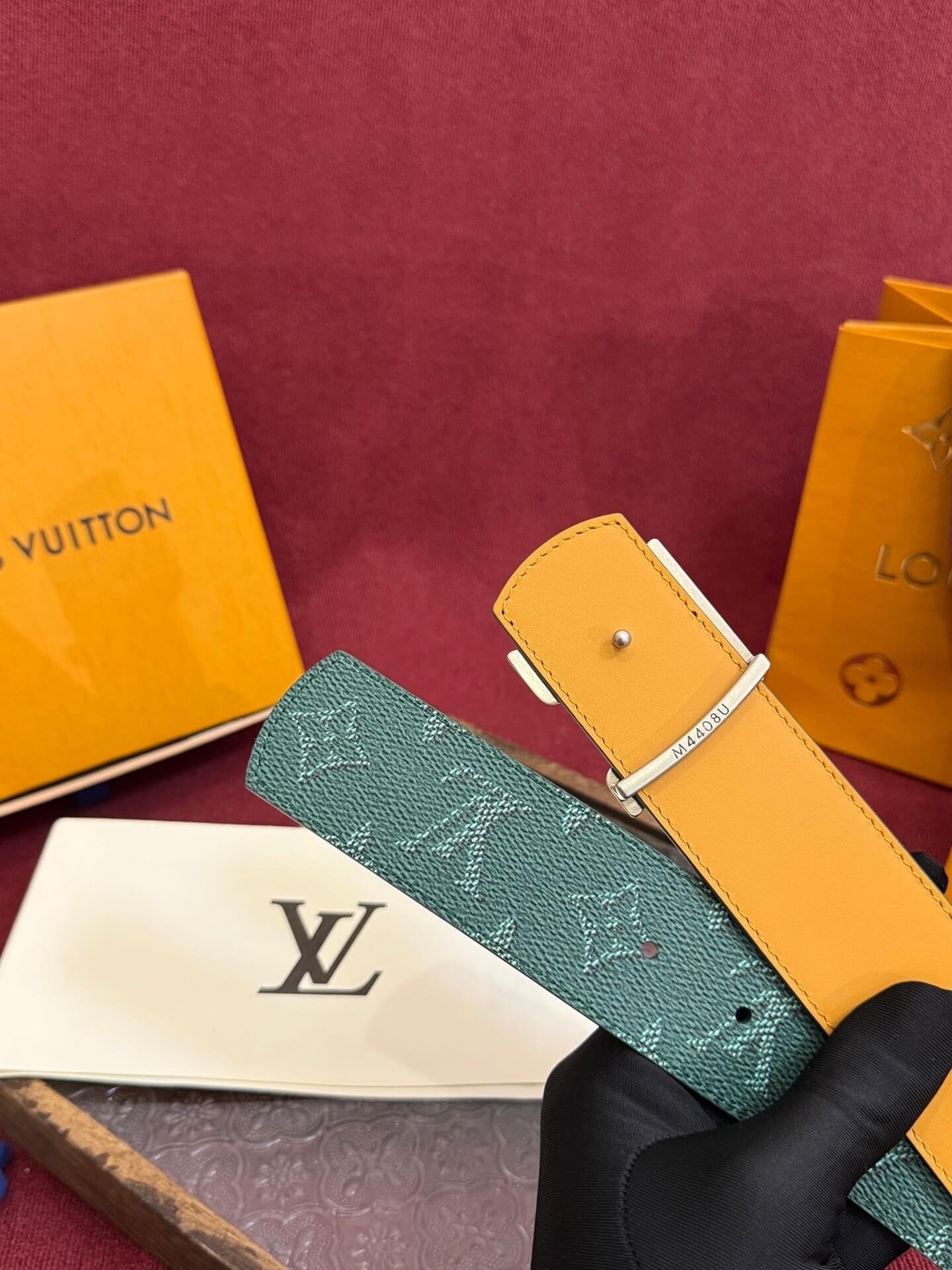 Louis Vuitton belts and packaging on a red background