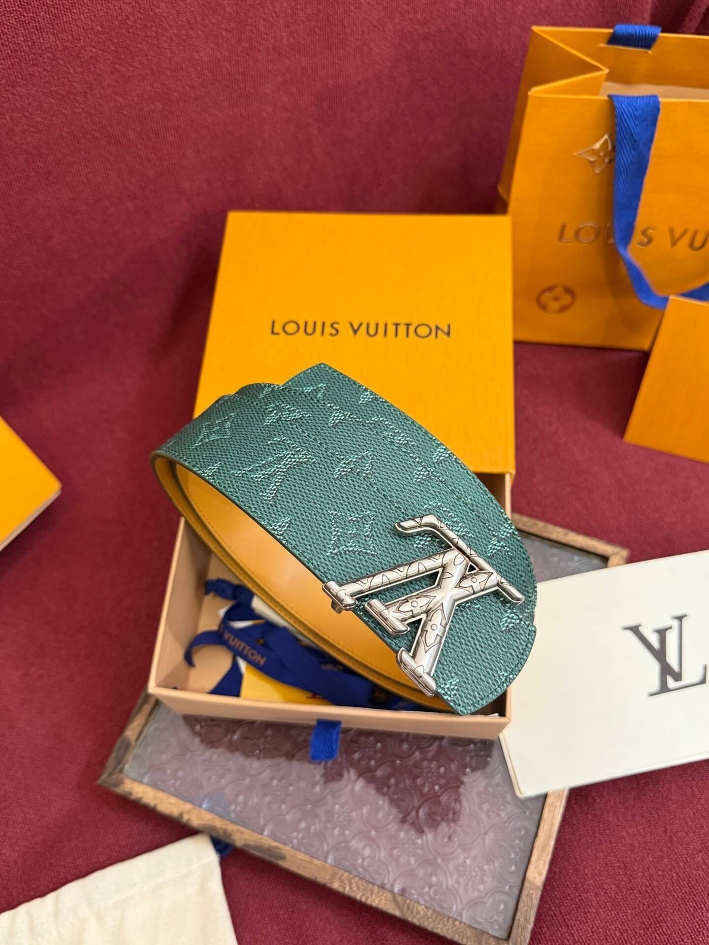 Louis Vuitton keychain with monogram pattern on a red fabric background
