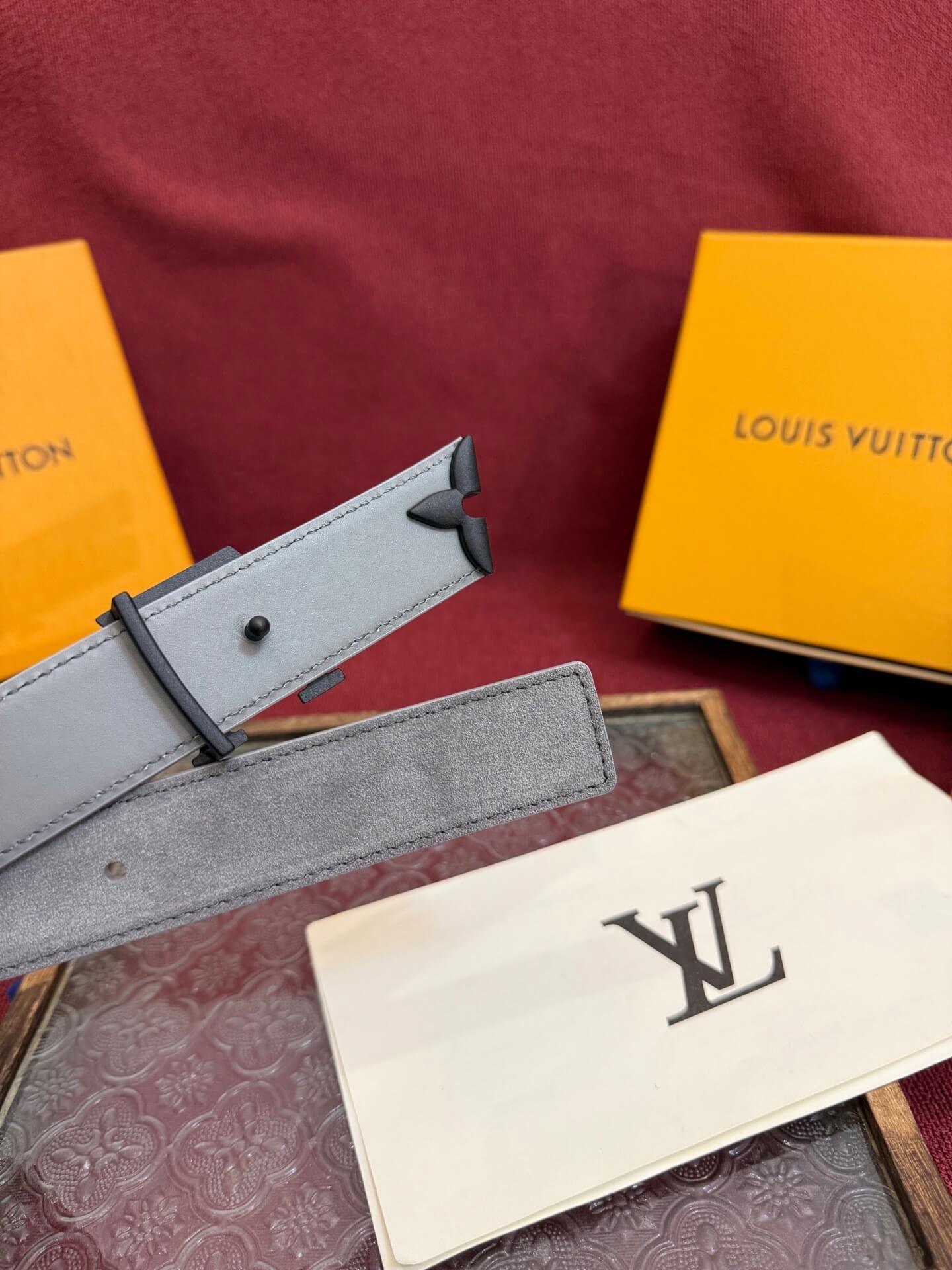 Louis Vuitton belt and packaging on a patterned surface