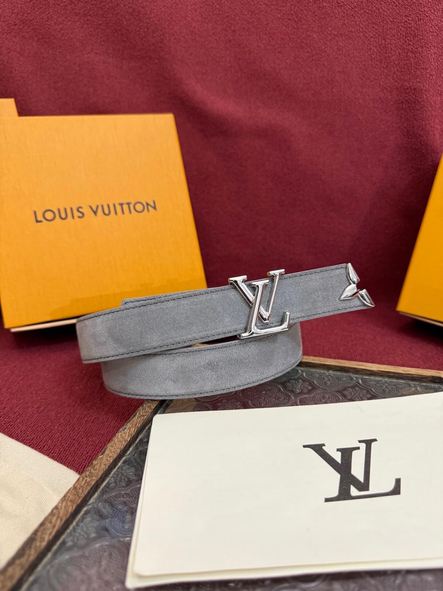 Louis Vuitton belt with packaging on a red surface