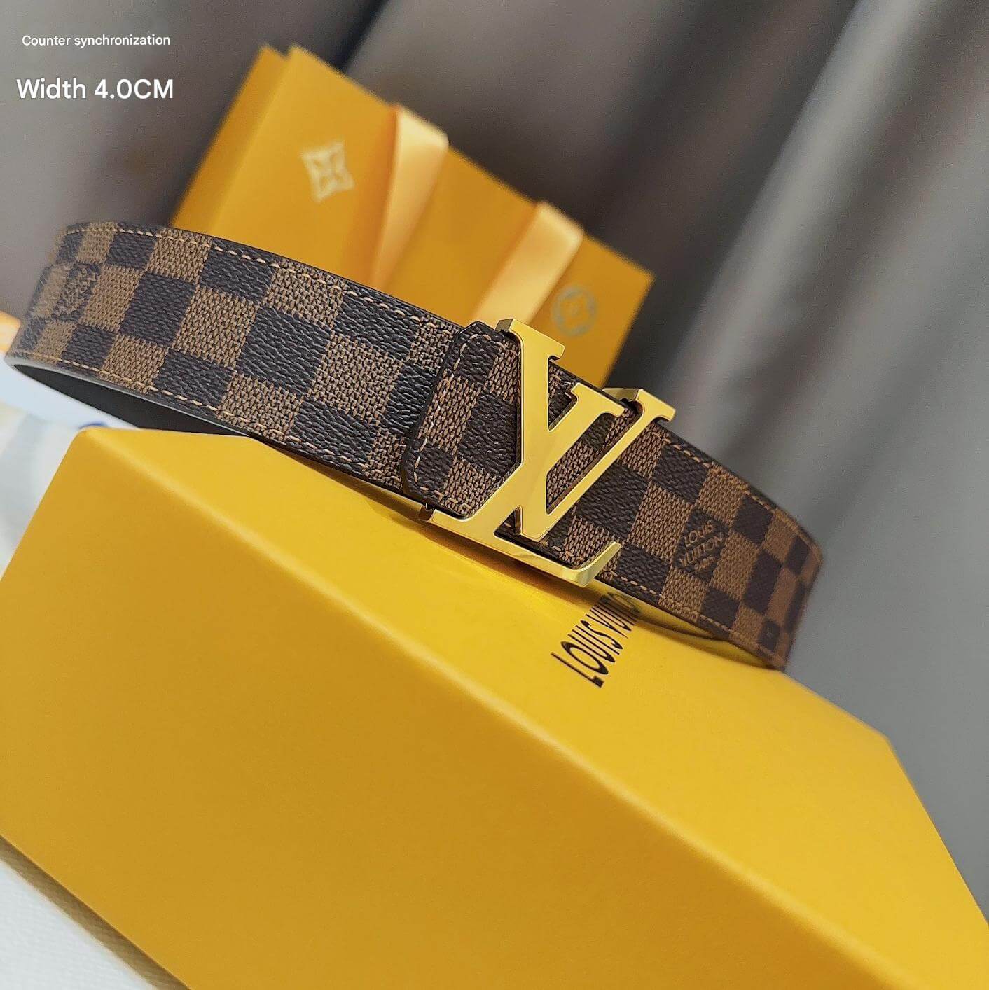 Louis Vuitton belt with gold buckle on a yellow box