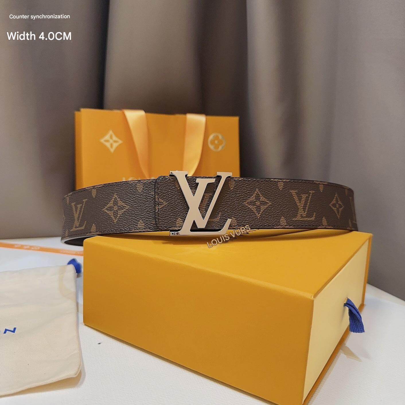 Louis Vuitton belt with monogram pattern and silver buckle on a yellow box.