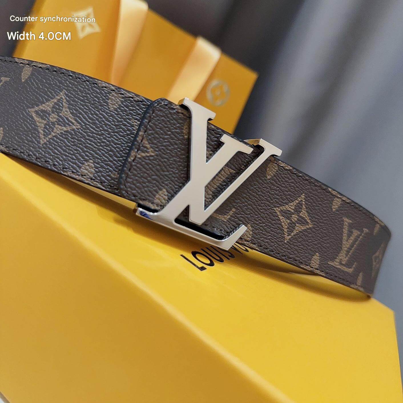 Louis Vuitton belt with monogram pattern on a yellow surface
