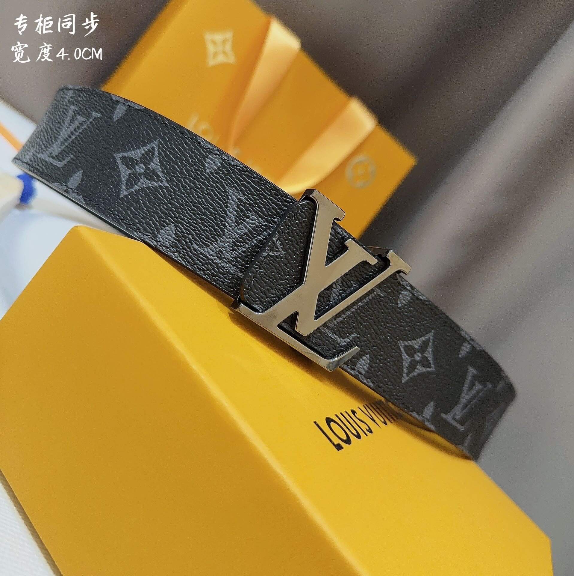 Louis Vuitton belt on a yellow box with brand logo.