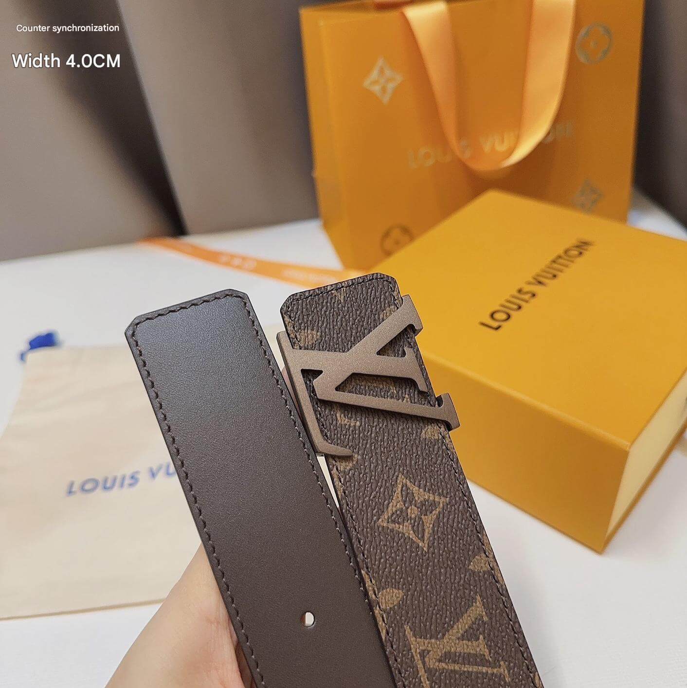Louis Vuitton belt with monogram pattern and packaging in the background