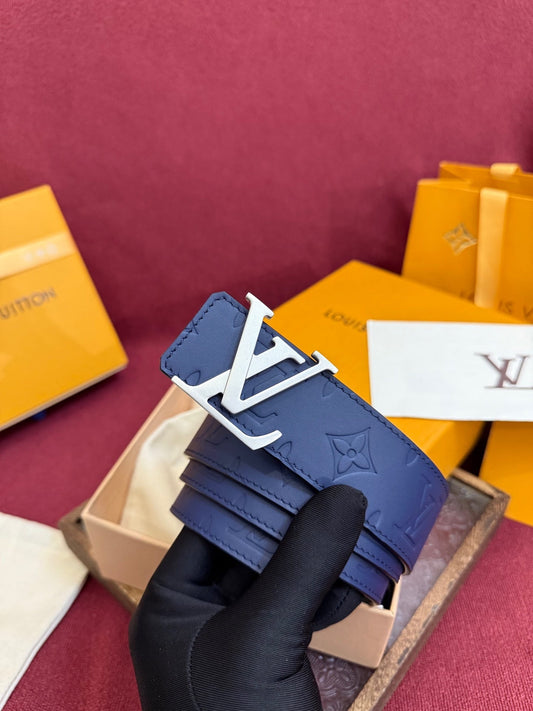 Blue belt with a white logo held by a gloved hand against a maroon background with Louis Vuitton packaging.