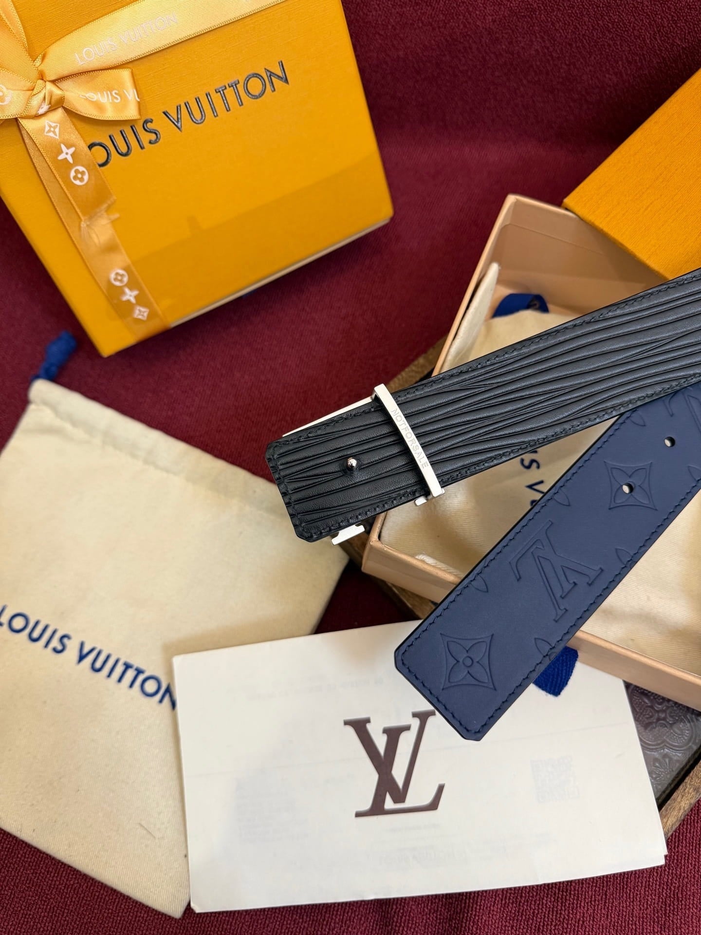 Louis Vuitton watch strap with packaging on a red background