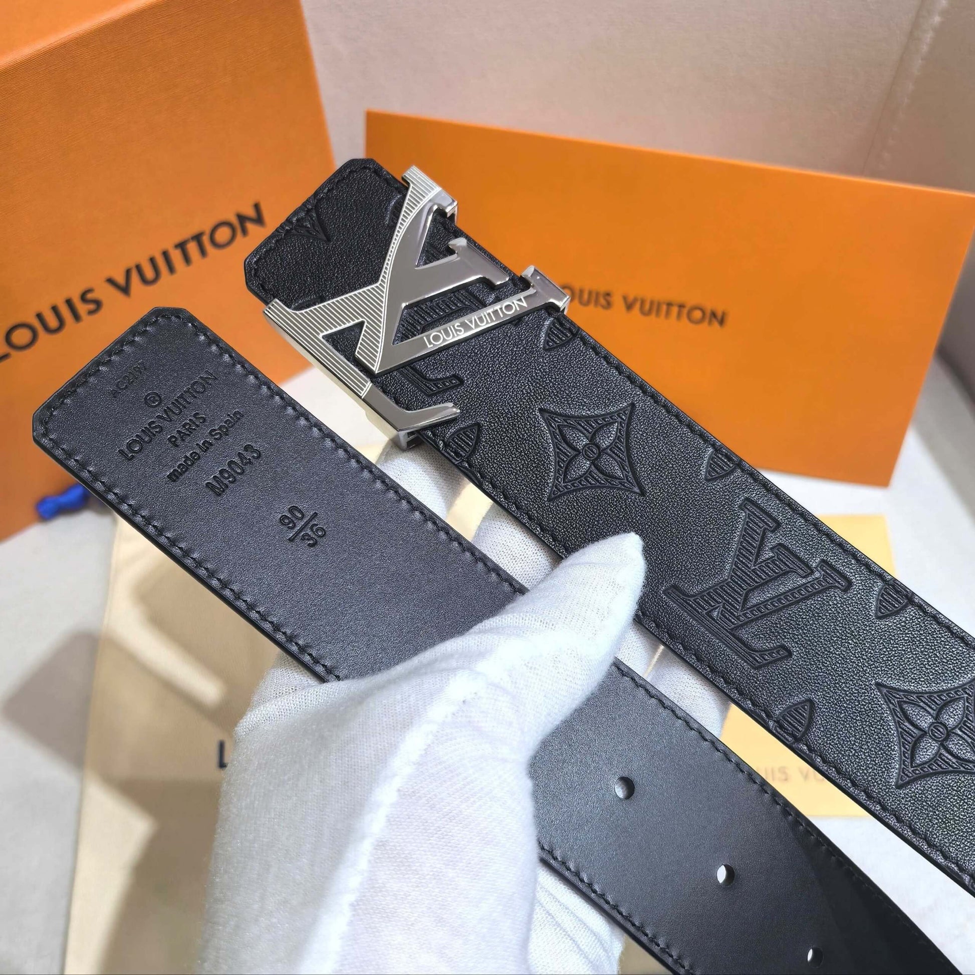 Louis Vuitton belt with monogram pattern on an orange Louis Vuitton box background