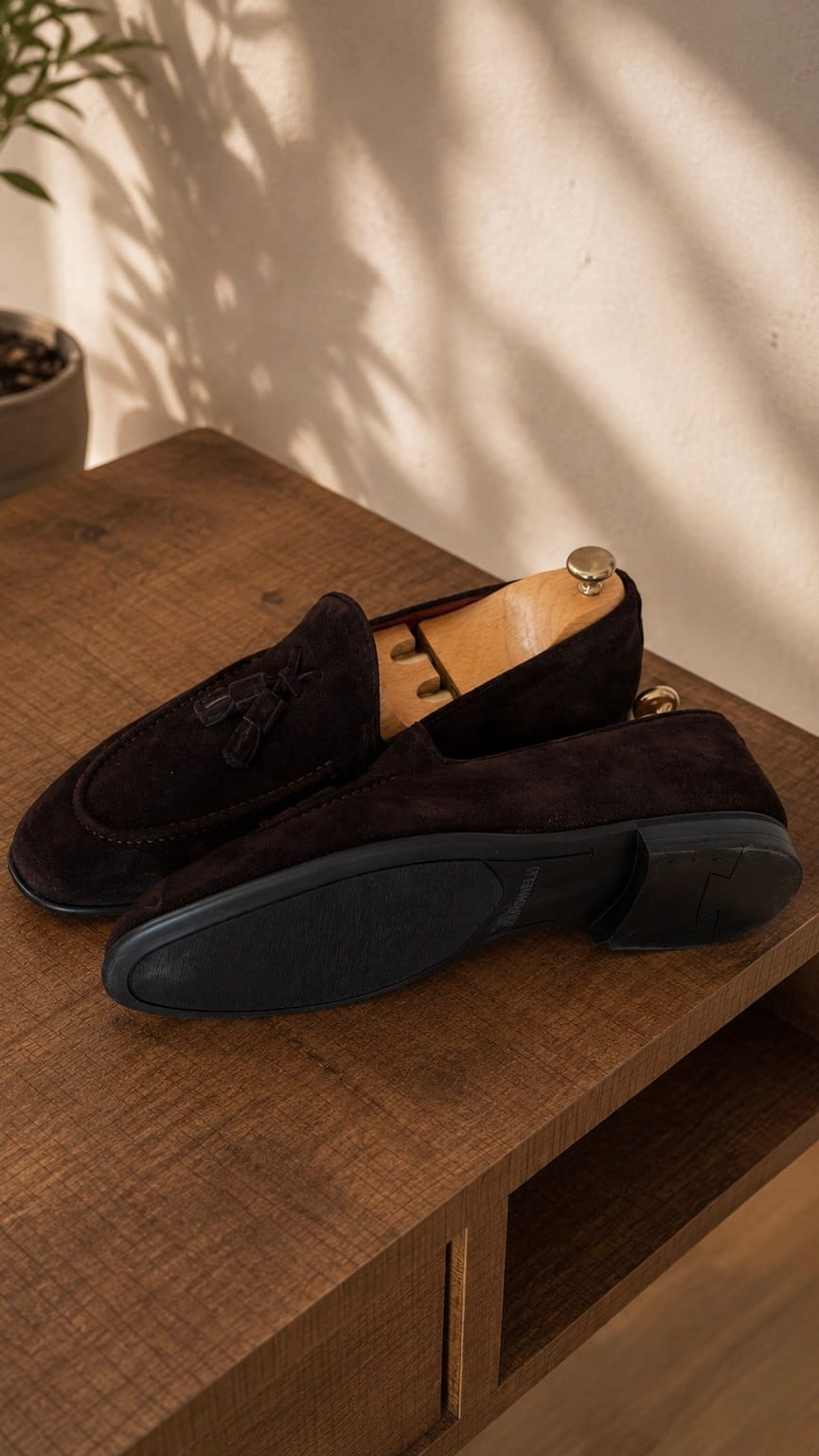 Outsole view of Lucca dark brown suede tassel loafers showing the black dress sole