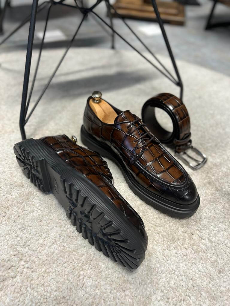Luxurious Brown Crocodile Leather Shoes – pair with one shoe upright and one showing the textured sole, alongside a matching belt, for distinguished style.