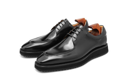 Overhead view of a pair of HolloShoe Black Apron-Toe Derby shoes, showcasing their sleek design and high-shine black leather finish.