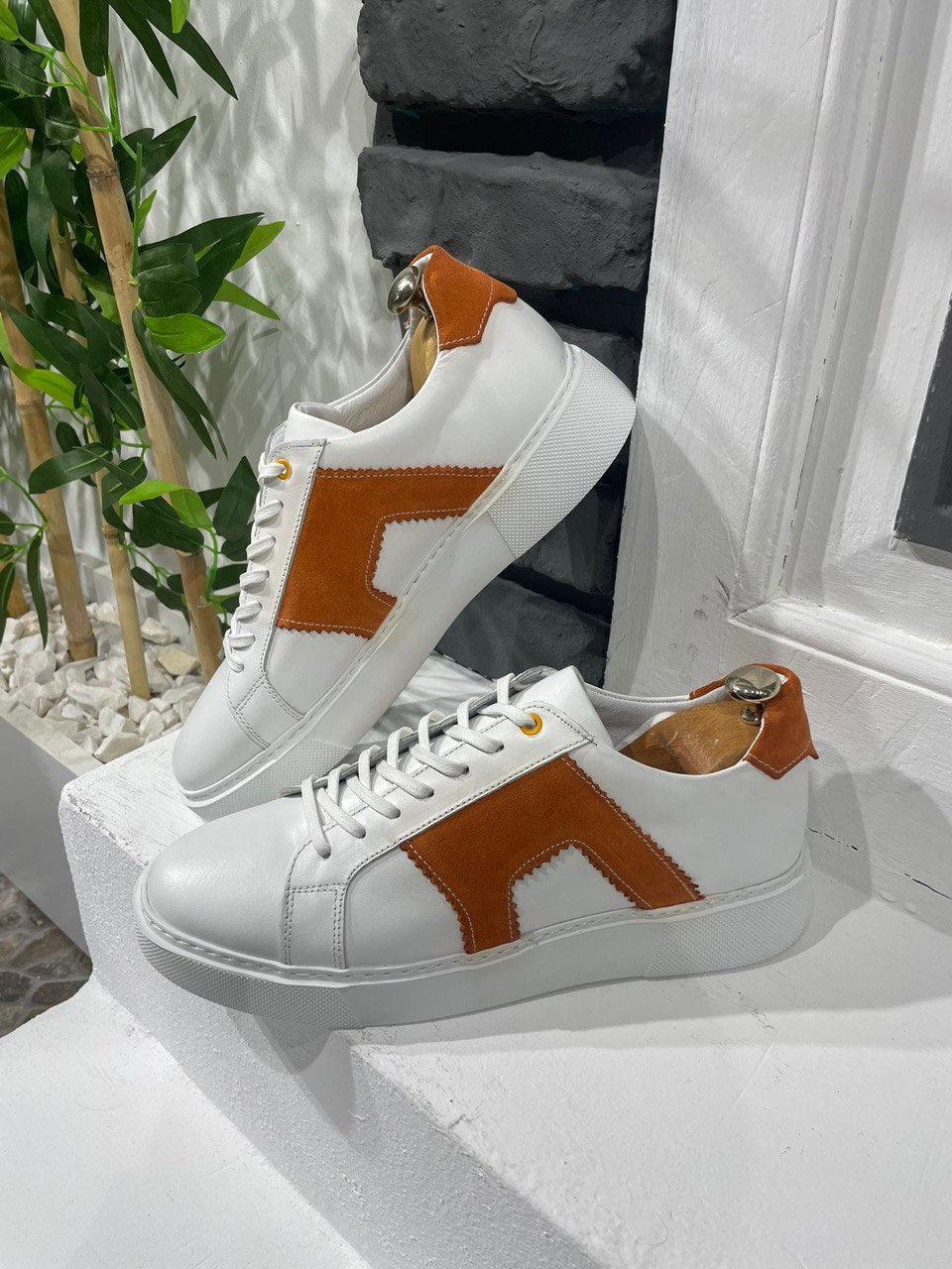 Modern White Orange Sneakers for Everyday Casual Wear – pair on a white ledge, highlighting a modern take on classic design with a clean white leather upper.