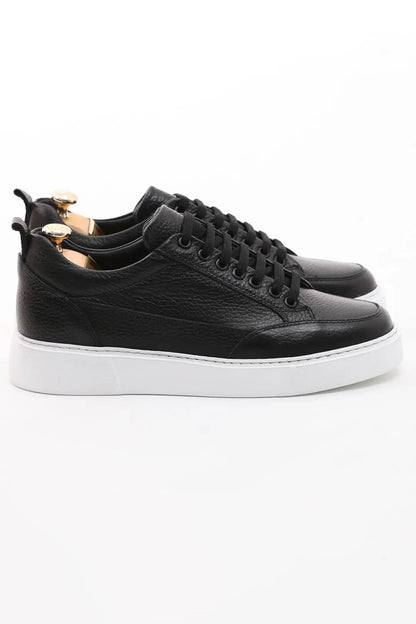 Onyx Luxe Black Leather Sneaker - Elegant Men's Footwear – side profile of one shoe, showcasing premium black floater leather and a contrasting white sole.