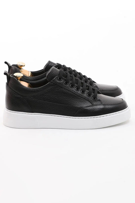 Onyx Luxe Black Leather Sneaker - Elegant Men's Footwear – side profile of one shoe, showcasing premium black floater leather and a contrasting white sole.