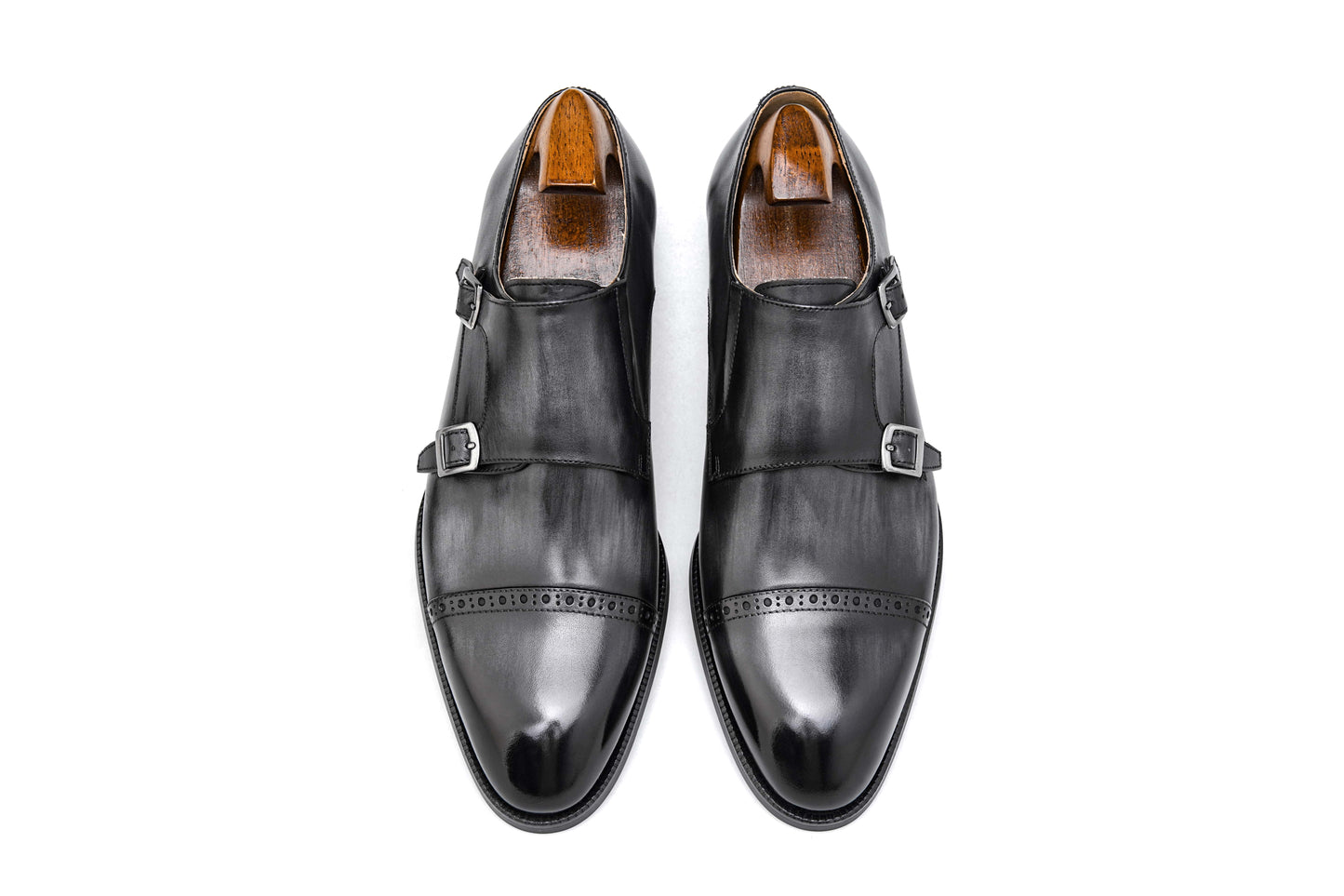 Polished Black Double Monk Strap Leather Shoes – pair with shoe trees, top-down view, showcasing high-gloss full-grain leather and cap-toe broguing.